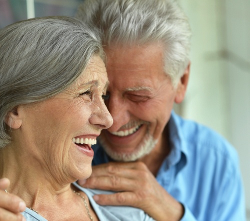 Man and woman smiling after teeth whitening treatment