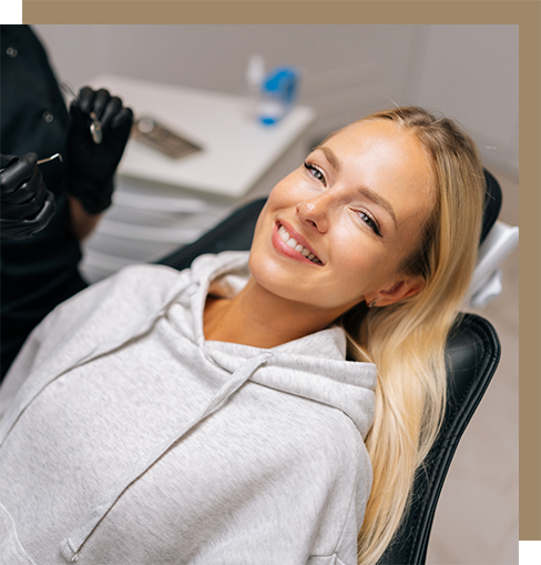 Smiling blonde woman leaning back in the dental chair