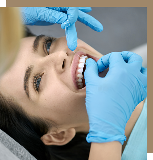 Dental hygienist flossing a patient's teeth