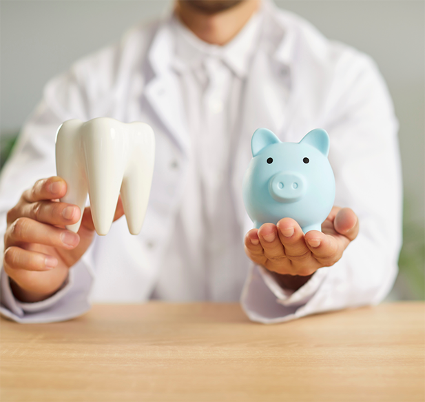 Dentist holding a piggy bank and a model of a tooth