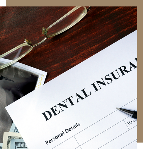 Dental insurance paperwork on a desk with pens and x-rays of teeth
