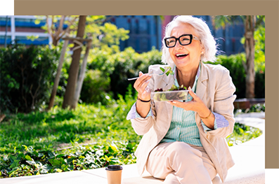 Woman sitting on an outdoor bench with a salad