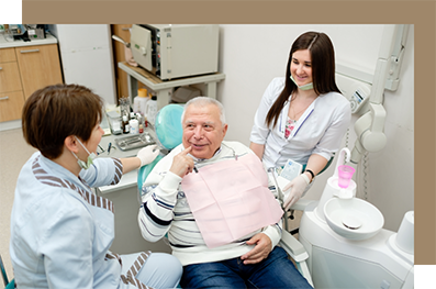 Senior man talking with his dentist and a dental assistant