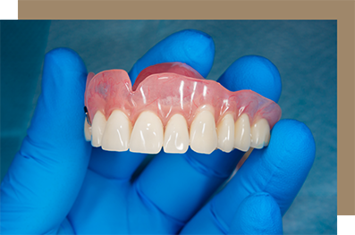 Dentist holding a full denture