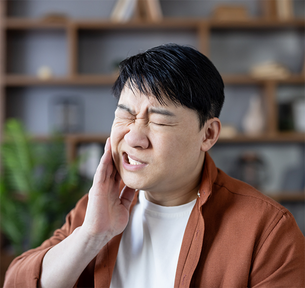 Man holding the side of his face in pain