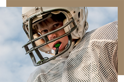 Football player wearing a mouthguard attached to his helmet