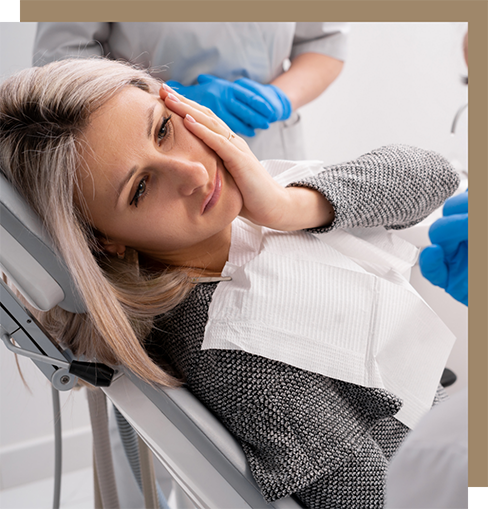 Woman holding her cheek in pain while talking to her emergency dentist in Cocoa Beach