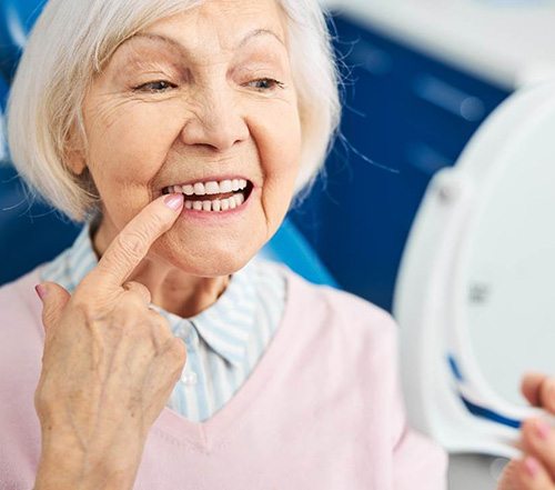 Senior female dental patient checking her teeth