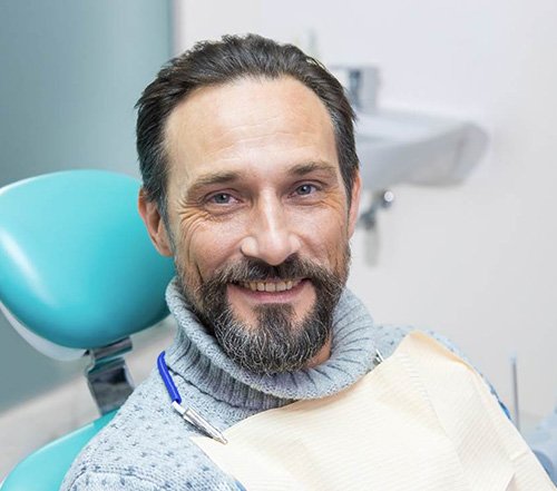 Bearded male dental patient smiling in dental chair