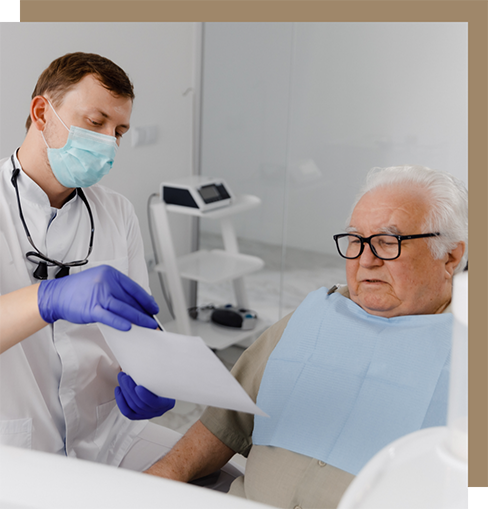 Dentist showing a sheet of paper to an older male patient