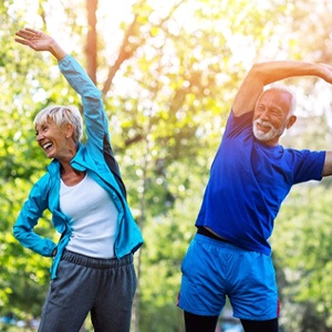 senior man and woman stretching before they exercise outside