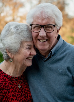 Man and woman smiling after replacing missing teeth