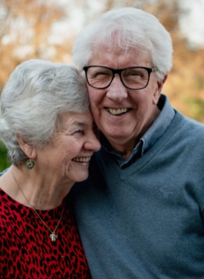 Older man and woman laughing outdoors