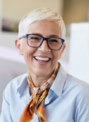 Woman with white hair smiling indoors