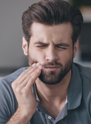 Man holding his cheek in pain