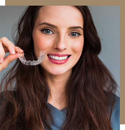 Brunette woman holding a clear aligner