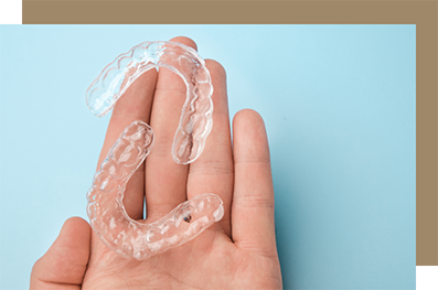 Two clear aligners in an open palm