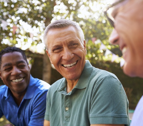 Man smiling after treatment to address gum disease symptoms