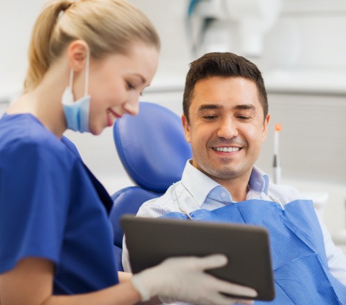 Man talking to dental team member during gum disease treatment visit
