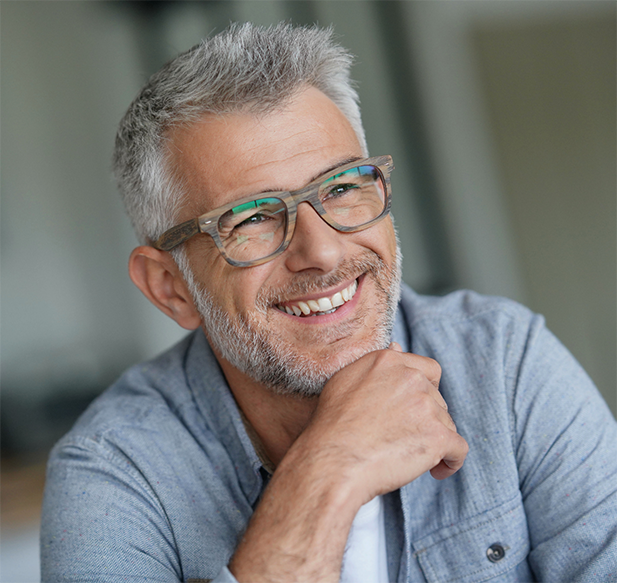 Man with short gray hair and glasses smiling