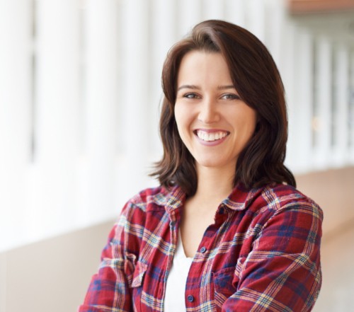 Woman with dental crown sharing flawless smile