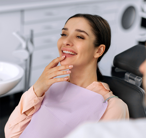 Young woman in the dental chair with her hand under her chin