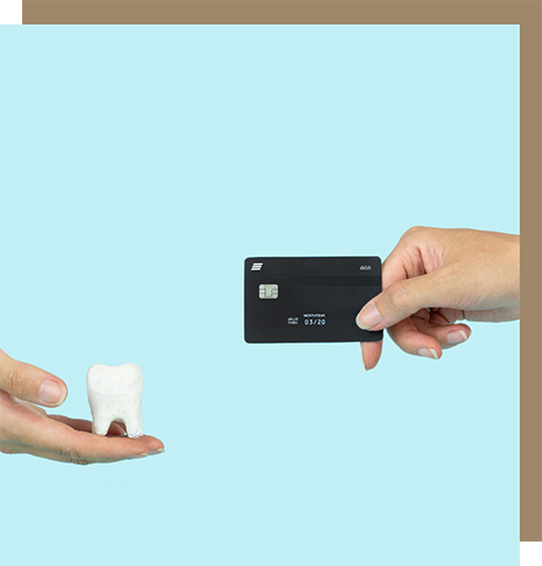 Hands exchanging a credit card for a model of a tooth