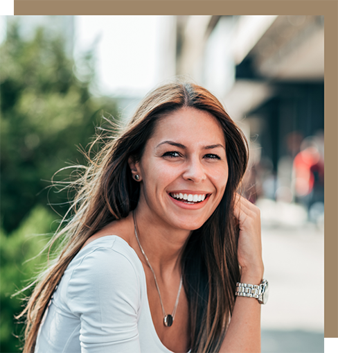 Woman with long straight brown hair smiling outdoors