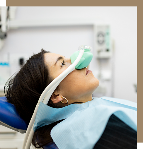 Woman in the dental chair wearing a nitrous oxide sedation mask over her nose