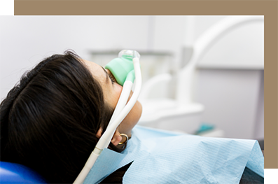 Woman waiting in the dental chair with a nitrous oxide mask over her nose