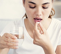 Woman taking oral conscious dental sedation pill