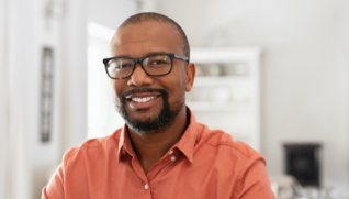 Man smiling after replacing missing teeth