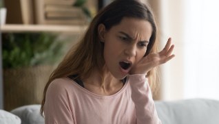 Woman in need of emergency dentistry holding cheek in pain