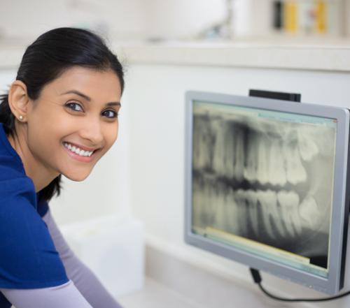 Woman looking at digital dental x-rays on computer screen
