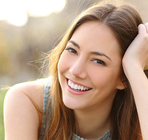 Young woman smiling outdoors with flawless white teeth