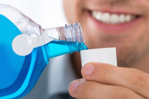 man using mouthwash