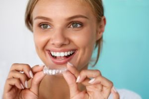 A woman holding a whitening tray.