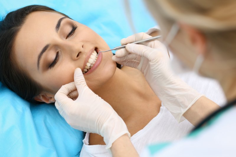 a woman having her teeth checked at the dentist’s office