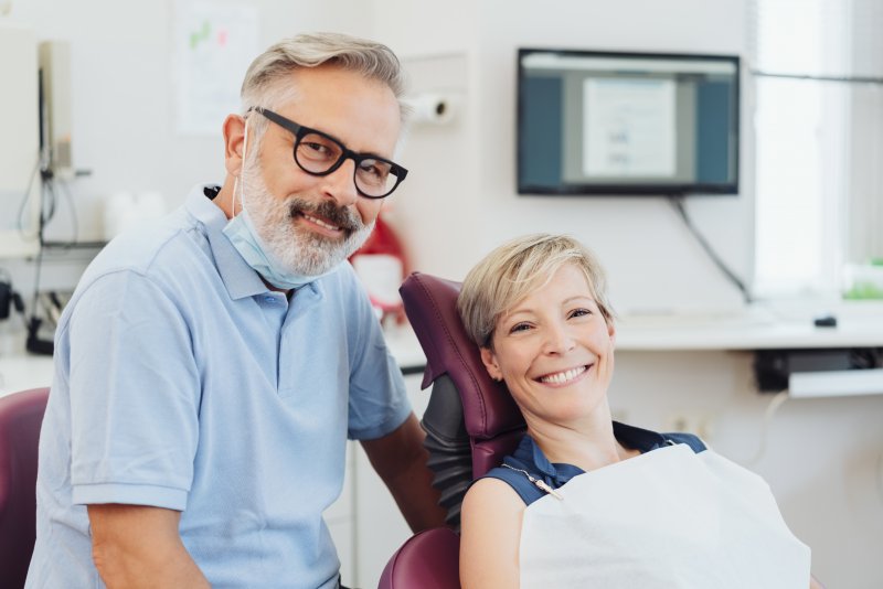 a dentist and female patient smiling