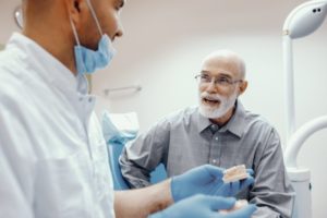 senior man talking to his dentist about All-on-4 dental implants 