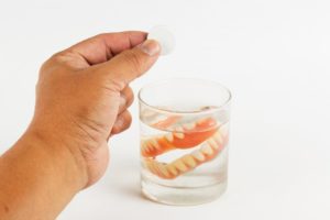 Caring for dentures by placing them in cleaning solution