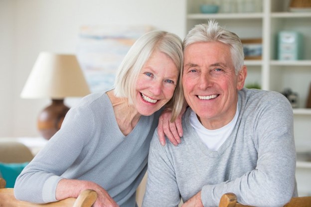 Older couple looking much younger after receiving dental implants. 