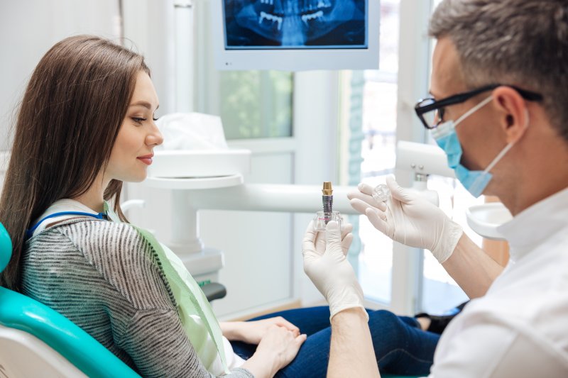 A woman talking to her dentist about dental implants