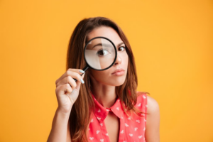 Woman holding a magnifying glass up to her eye