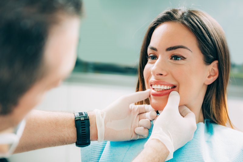 A dentist assessing a woman for cosmetic dentistry